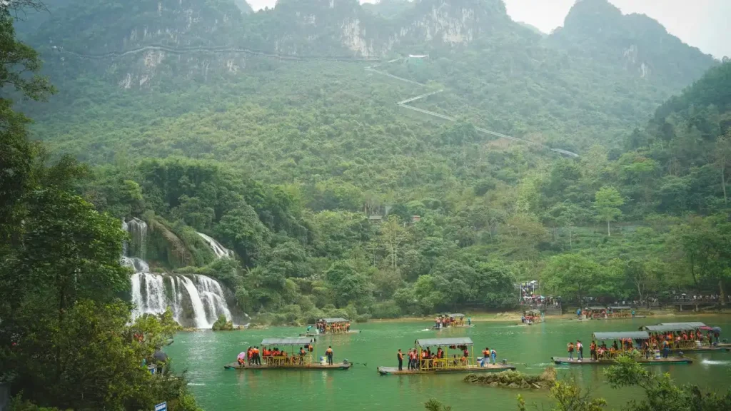 Tourists on a bamboo raft near the splashing Ban Gioc Waterfall