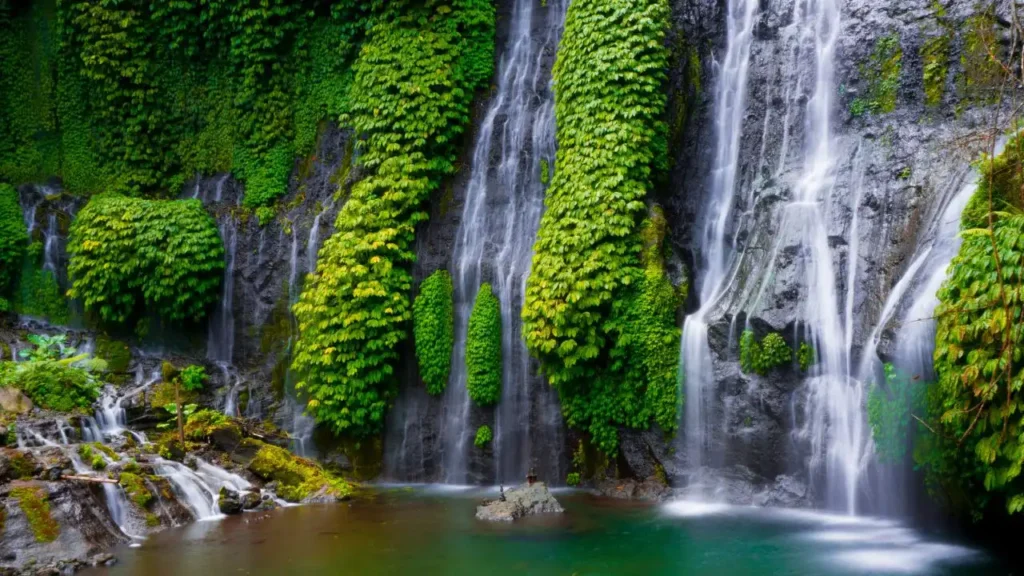 A stunning wide view of the Banyumala Twin Waterfalls in North Bali with lush green jungle