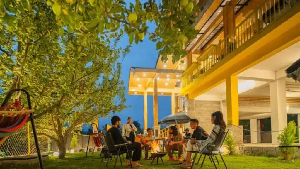 A cozy backpacker hostel common room with mountain views in Old Manali.