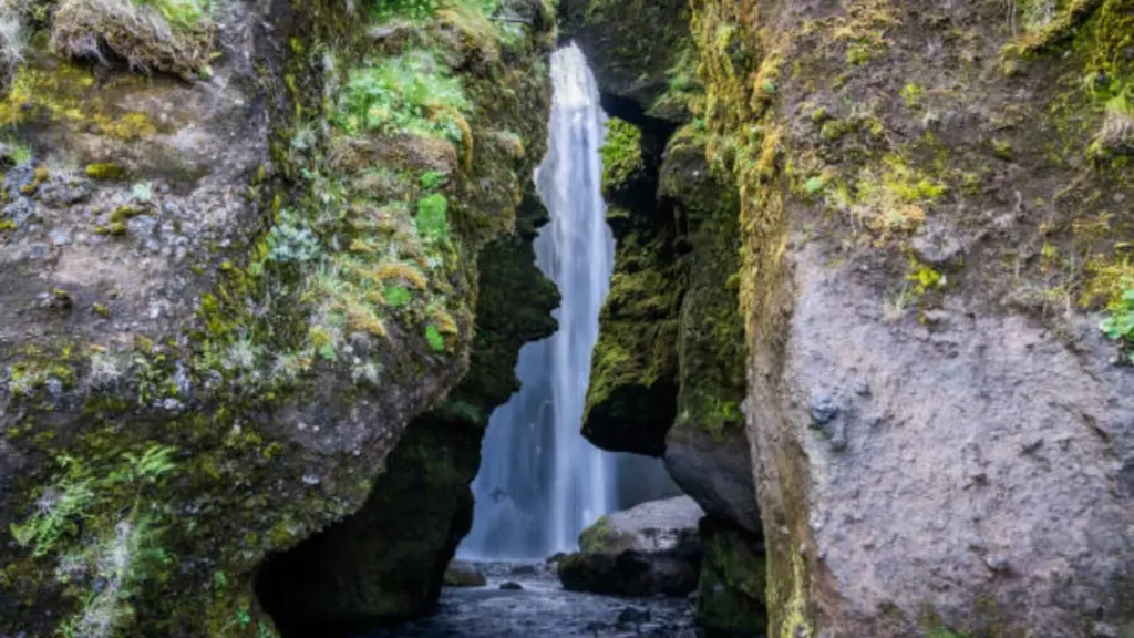 The narrow entrance between rocks leading to the hidden Gljúfrabúi waterfall