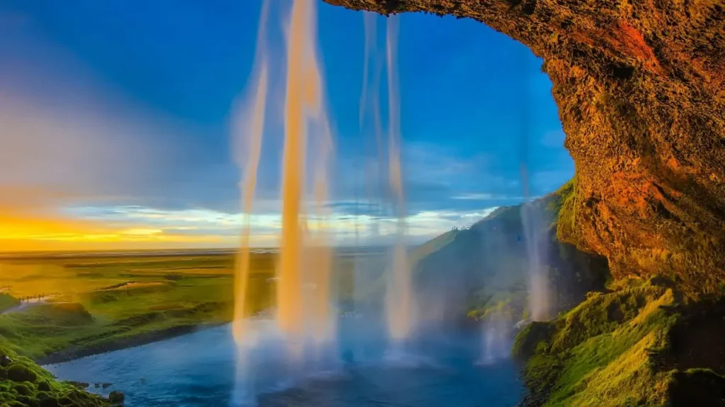 A majestic wide shot of Seljalandsfoss waterfall in Iceland during a golden sunset