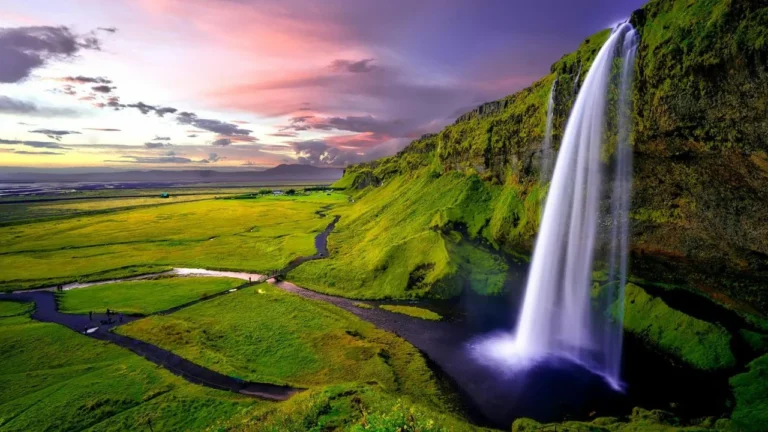 A majestic wide shot of Seljalandsfoss waterfall in Iceland during a golden sunset